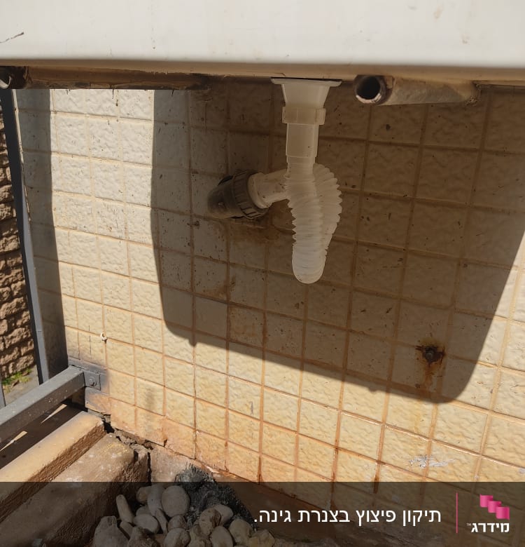 צינור פלסטיק לבן מחובר לקיר אריחים